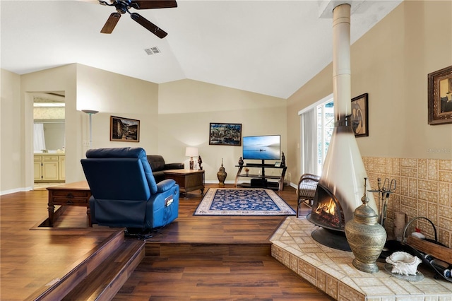 living room with a ceiling fan, vaulted ceiling, wood finished floors, and visible vents