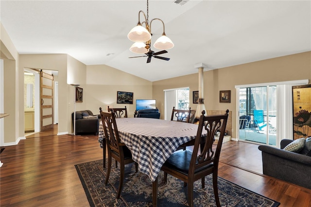 dining space featuring ceiling fan, lofted ceiling, a barn door, and wood finished floors