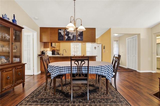 dining area featuring a chandelier, baseboards, and dark wood-style floors