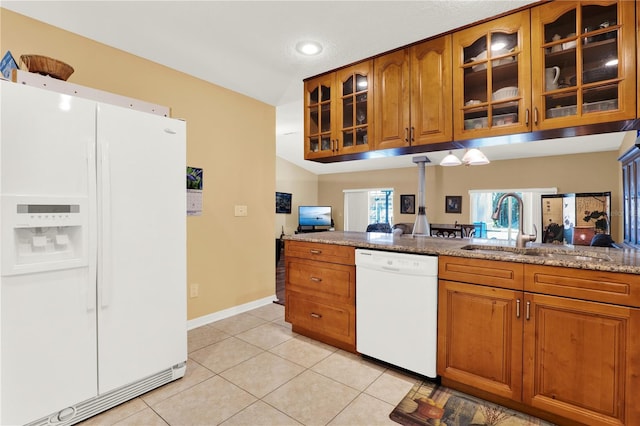 kitchen featuring brown cabinets, white appliances, and a sink