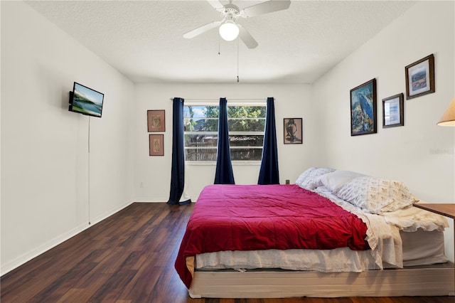 bedroom with ceiling fan, baseboards, a textured ceiling, and wood finished floors