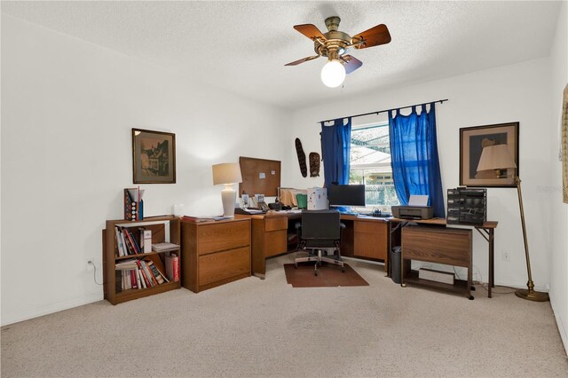 office space featuring ceiling fan, light colored carpet, and a textured ceiling