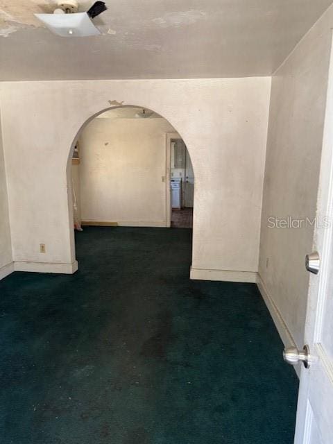 unfurnished room with baseboards and arched walkways