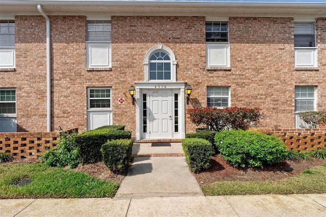 entrance to property featuring brick siding