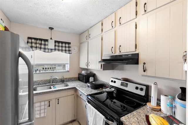 kitchen featuring pendant lighting, stainless steel appliances, a sink, a textured ceiling, and under cabinet range hood