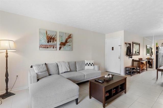 living room featuring a textured ceiling, light tile patterned floors, and baseboards