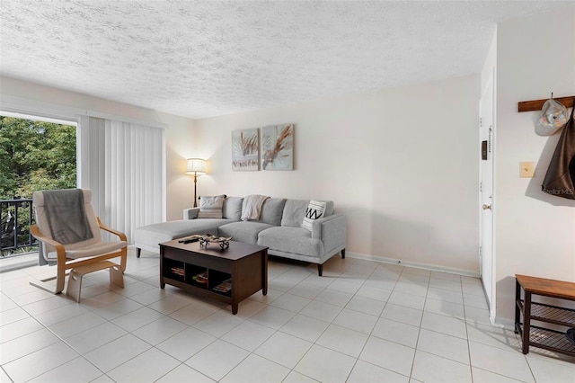 living area featuring a textured ceiling, baseboards, and light tile patterned floors