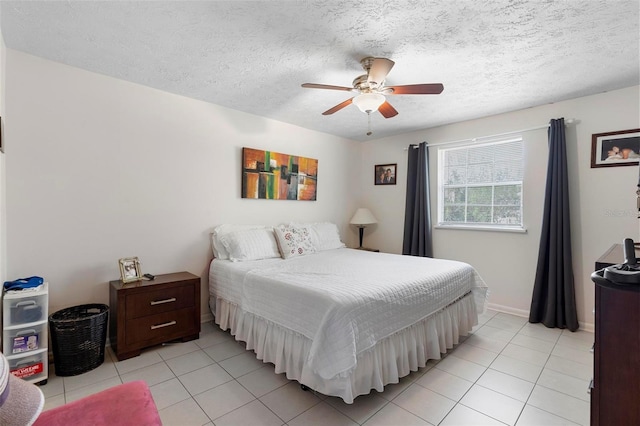 bedroom with light tile patterned floors, a textured ceiling, a ceiling fan, and baseboards