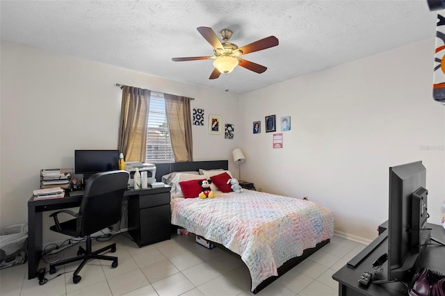 bedroom with ceiling fan, light tile patterned floors, a textured ceiling, and baseboards