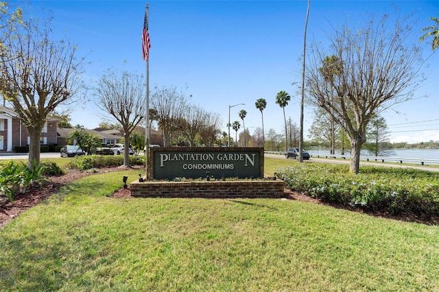 community / neighborhood sign featuring a yard and a water view