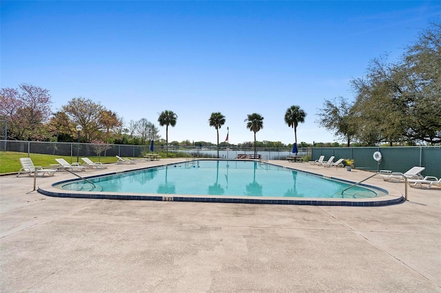 community pool with fence and a patio