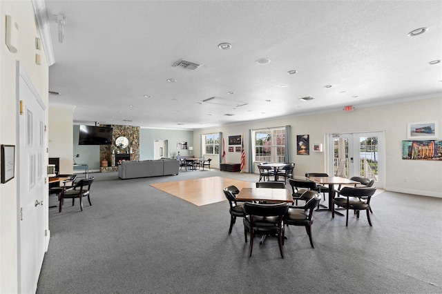 dining area with a textured ceiling, visible vents, baseboards, french doors, and ornamental molding