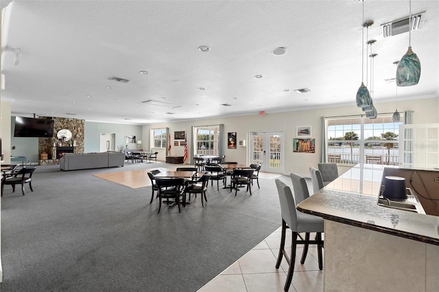 dining space featuring light tile patterned flooring, visible vents, ornamental molding, and french doors