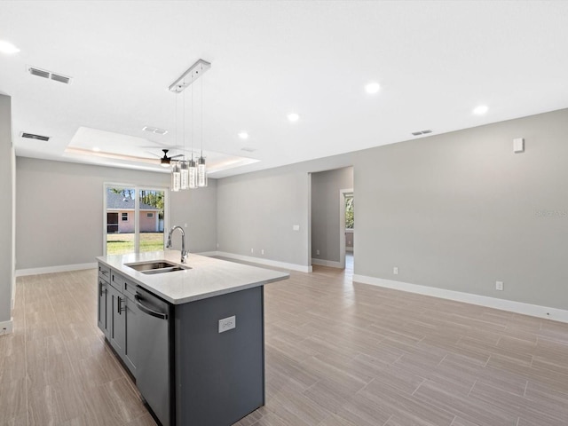 kitchen with a sink, visible vents, open floor plan, stainless steel dishwasher, and a raised ceiling