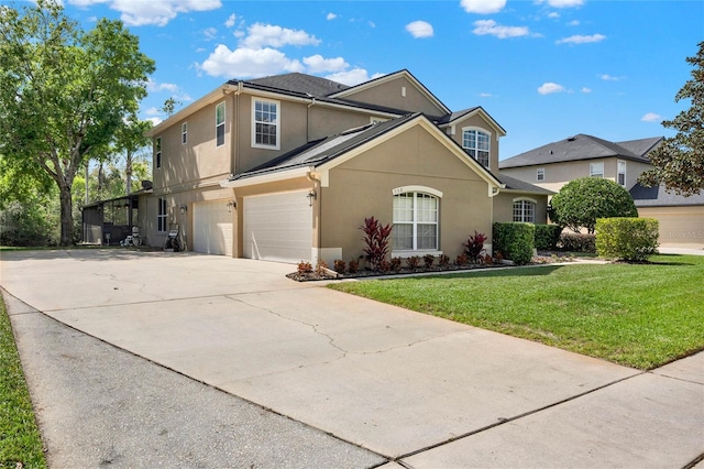 traditional-style house featuring a garage, a front yard, driveway, and stucco siding