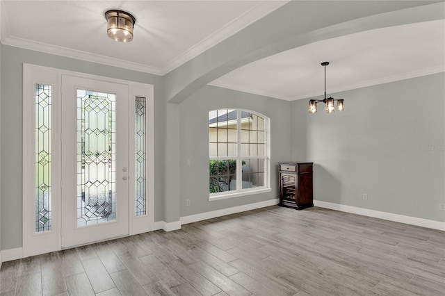 entrance foyer featuring ornamental molding, wood finished floors, and baseboards