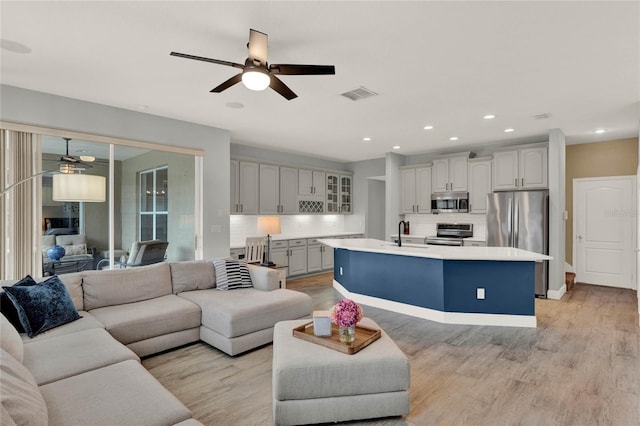 living area featuring a ceiling fan, recessed lighting, visible vents, and light wood-style flooring