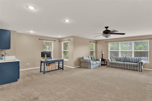 living room with a healthy amount of sunlight, recessed lighting, baseboards, and light colored carpet