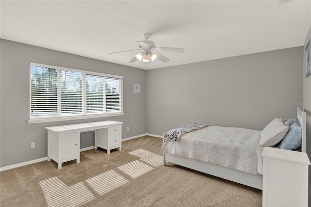 bedroom featuring a ceiling fan, light carpet, and baseboards