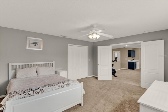 bedroom with a closet, visible vents, light carpet, ceiling fan, and baseboards