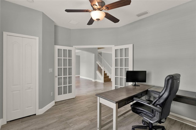 office featuring wood finished floors, a ceiling fan, visible vents, baseboards, and french doors