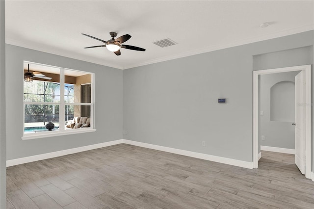 empty room featuring light wood-style flooring, visible vents, a ceiling fan, and ornamental molding