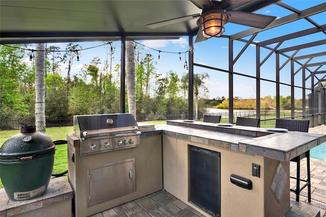 view of patio with grilling area, outdoor wet bar, a lanai, a fenced backyard, and exterior kitchen