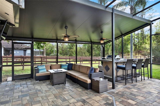 view of patio / terrace featuring outdoor dry bar, a ceiling fan, fence, a lanai, and an outdoor living space