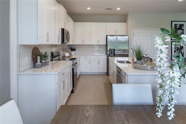1578 Sky Lakes Dr, Saint Cloud, FL 34769 - kitchen with stainless steel appliances, white cabinets, light countertops, and a sink