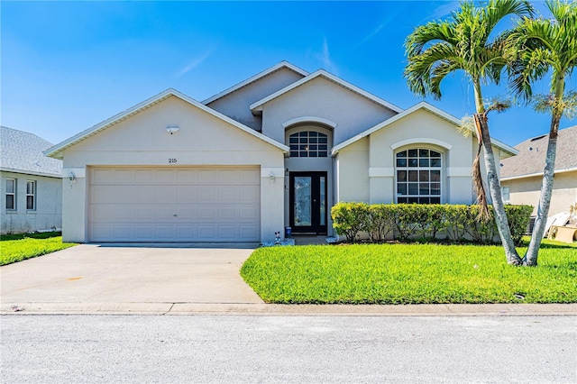 single story home featuring a garage, a front yard, driveway, and stucco siding