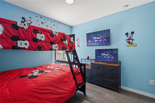 bedroom with baseboards and wood finished floors