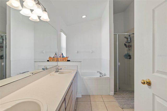 bathroom with tile patterned flooring, a garden tub, a stall shower, and a sink