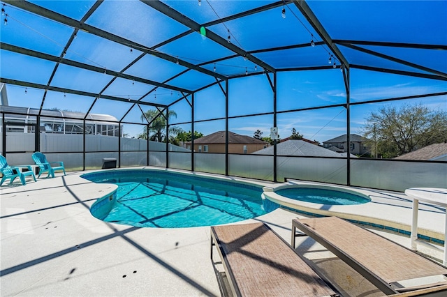 view of pool featuring glass enclosure, a patio area, and a pool with connected hot tub