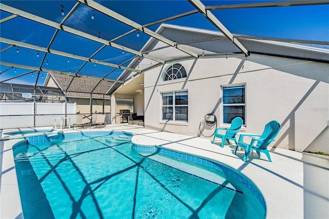 view of pool with glass enclosure, a patio, and a pool with connected hot tub