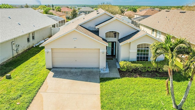 view of front of property featuring a residential view, a front yard, stucco siding, a garage, and driveway