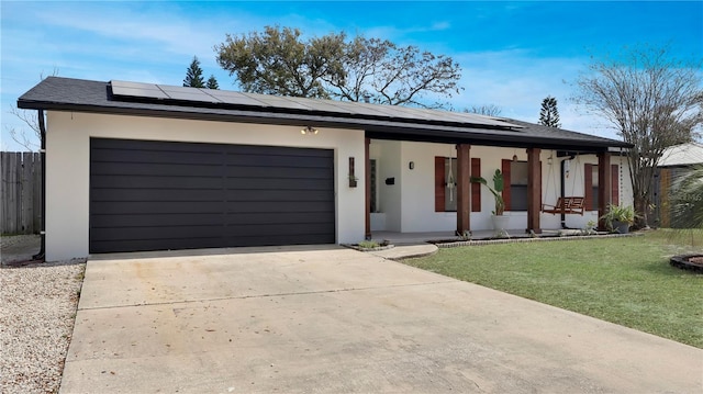 ranch-style home featuring roof mounted solar panels, a front lawn, concrete driveway, and stucco siding