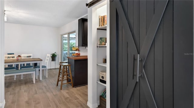 interior space with light wood-style floors, a textured ceiling, and a barn door