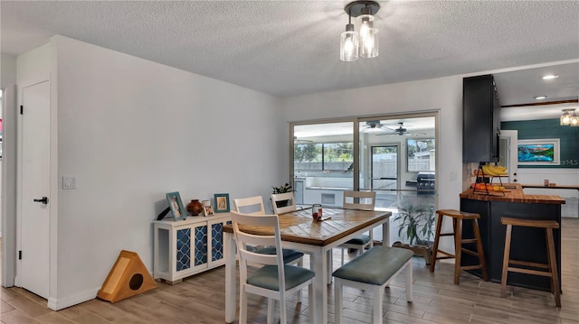 dining space with a textured ceiling and wood finished floors