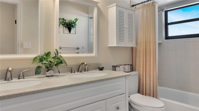 bathroom featuring double vanity, shower / bath combo, a sink, and toilet