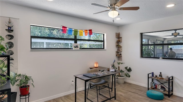 office space with a wealth of natural light, a textured ceiling, a ceiling fan, and wood finished floors