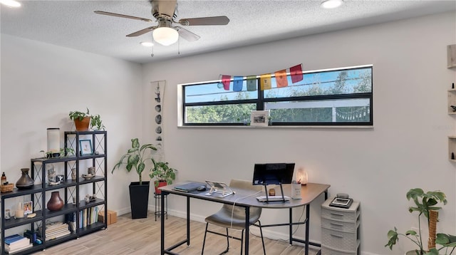 office space with a textured ceiling, wood finished floors, a ceiling fan, and baseboards