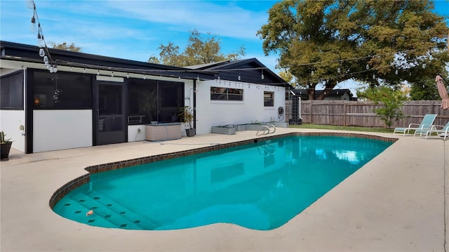 view of swimming pool featuring a patio area, a fenced backyard, a sunroom, and a fenced in pool