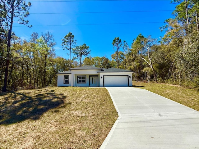 view of front of property with a front yard, a garage, driveway, and stucco siding