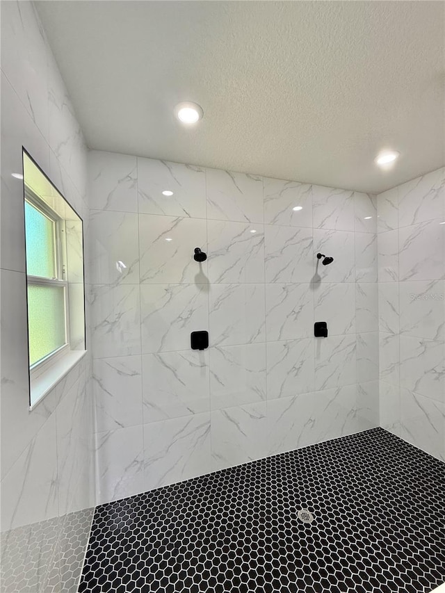 full bath featuring recessed lighting, a tile shower, and a textured ceiling