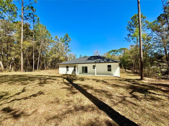 rear view of house featuring stucco siding