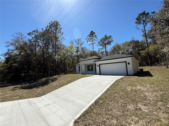 single story home featuring concrete driveway, an attached garage, a front yard, and stucco siding