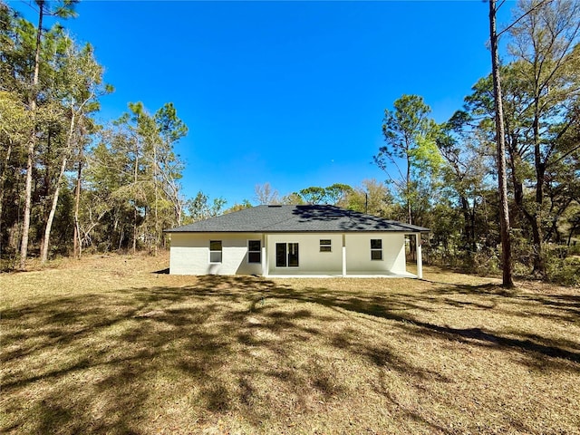 back of property featuring a patio, a yard, and stucco siding