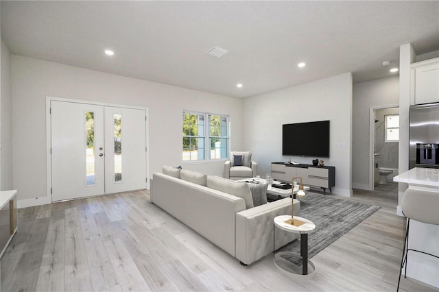 living area with visible vents, recessed lighting, french doors, and light wood-type flooring