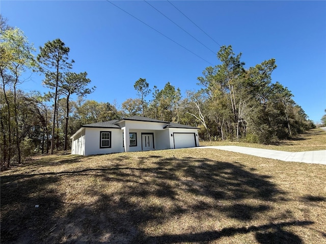 1792 W Lorraine Dr, Citrus Springs, FL 34434 - view of front facade with a garage, stucco siding, and concrete driveway