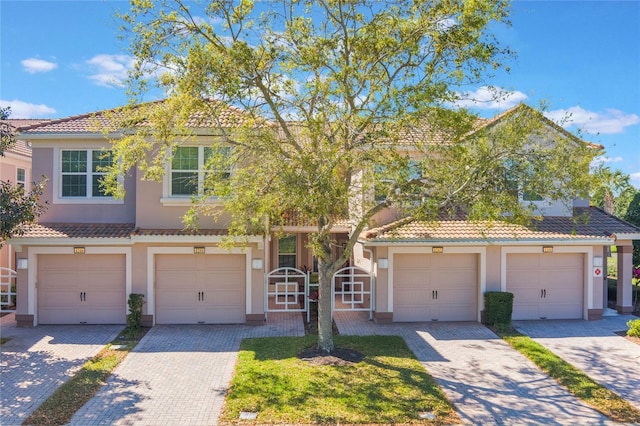 view of front of property featuring decorative driveway, a tiled roof, and stucco siding